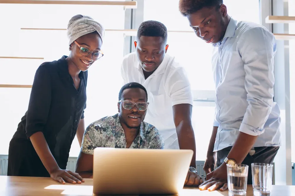 A finance team reviewing reports together on a laptop